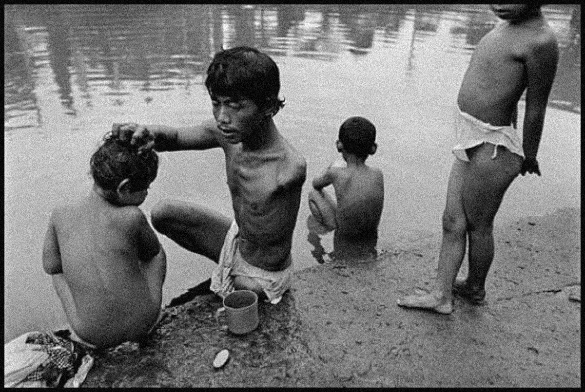 3-یک فرد معلول فرزندانش را با آب آلوده کانال می شوید. 1998، اندونزی، جیمز نچوی